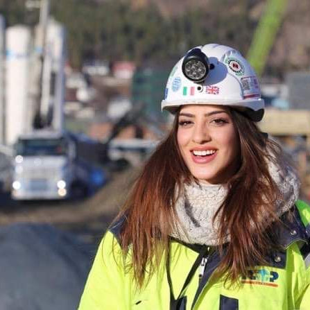 Donna con casco e giubbotto ad alta visibilità, simbolo del master ingegneri.